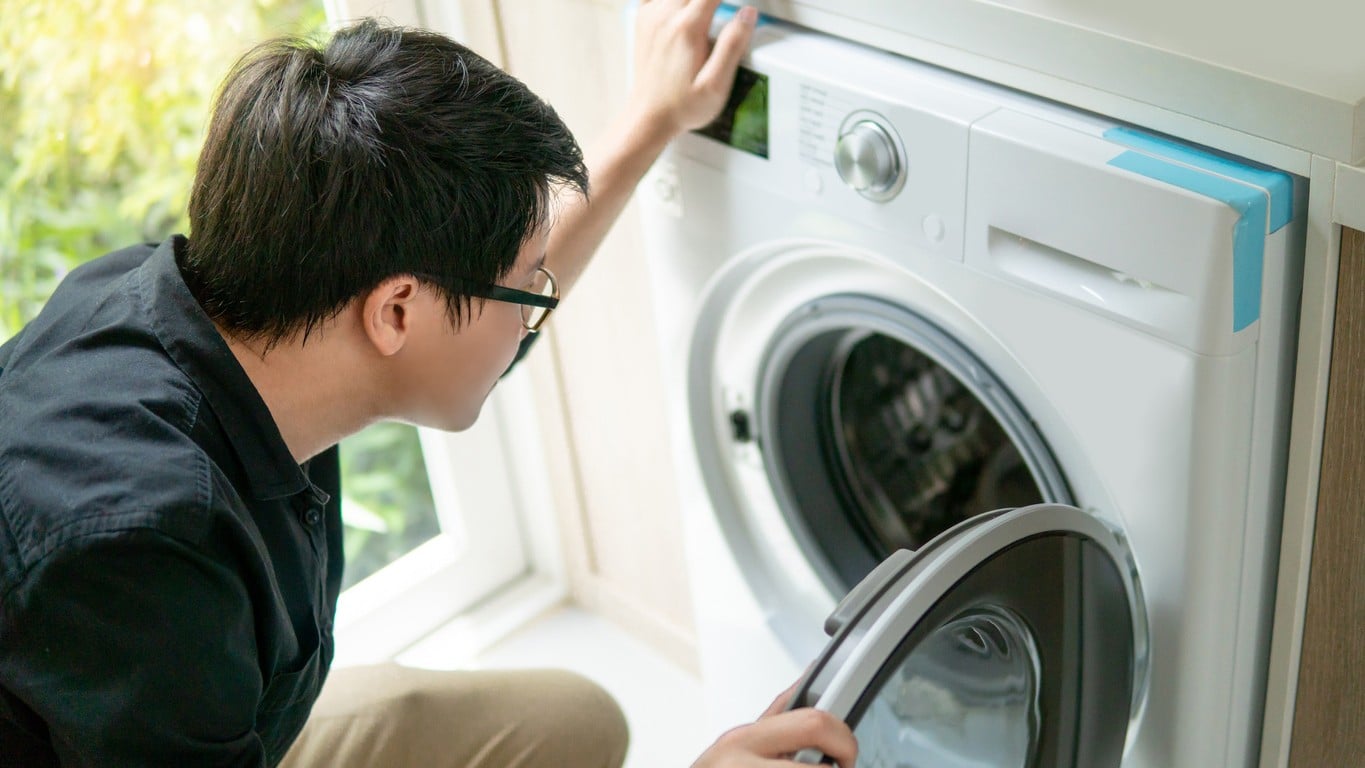 Service technician diagnosing issues with a dryer